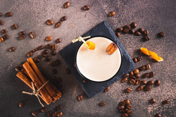 Close up of spanish coffee cocktail with cinnamon and orange zes Close up of spanish coffee cocktail with cinnamon and orange zest in a glass on table top view