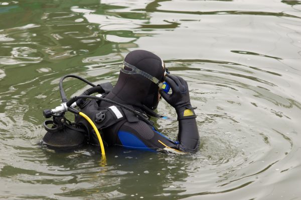 scuba diver entering the water Scuba diver in wet suit entering the cold water